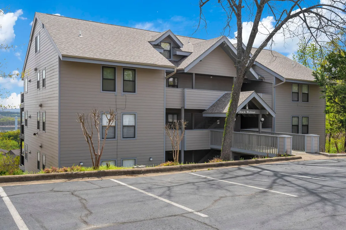 A bright exterior view of the condo building, featuring private balconies overlooking lush greenery. The image shows the inviting outdoor spaces guests can enjoy, reinforcing the idea of a relaxing retreat close to the action.